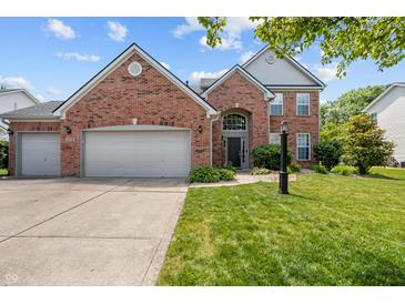 Charming brick two-story home with well-manicured lawn and two-car garage on a sunny day at 1319 Gable Lake Dr, Brownsburg, IN 46112