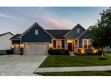 Charming home showcasing blue siding, brick accents, manicured lawn, and inviting two-car garage at 19009 Beverly Shones Ln, Noblesville, IN 46062