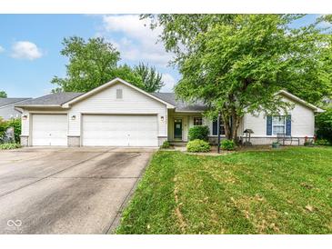 Charming single-story home boasts a two-car garage and beautifully landscaped front yard and great curb appeal at 20845 Summit Rd, Noblesville, IN 46062