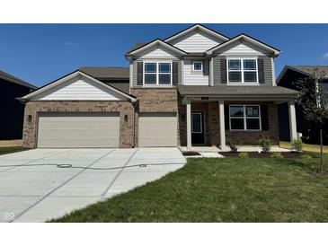 Charming two-story home featuring a brick facade, a spacious two-car garage, and a well-maintained lawn at 210 Ames Dr, Whiteland, IN 46184
