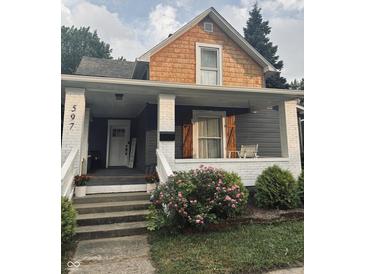 Charming home's front porch with swing, flowers, and well maintained landscape at 597 W Adams St, Franklin, IN 46131