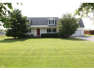 Charming two-story home with a well-manicured lawn, a red front door and inviting curb appeal at 6052 N Deckshire Ln, Shirley, IN 47384