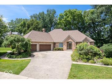 Charming brick ranch with manicured lawn, mature trees, and attached two-car garage at 7250 Royal Oakland Dr, Indianapolis, IN 46236