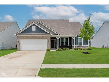 Charming home with a brick and siding facade, well-manicured lawn, and inviting front porch at 9806 Olympic Blvd, Pendleton, IN 46064