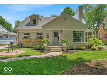Charming home with a manicured front lawn, flower boxes and a cozy brick pathway at 1149 E 56Th St, Indianapolis, IN 46220