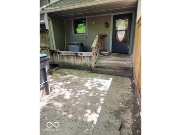 Exterior front entrance featuring a covered porch and weathered wooden steps at 4235 Foxglove Trce, Indianapolis, IN 46237