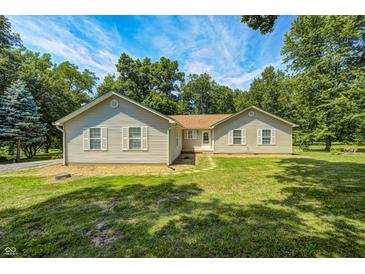 Charming single-story home with verdant lawn, surrounded by mature trees and a blue sky at 494 W Greencastle Rd, Mooresville, IN 46158