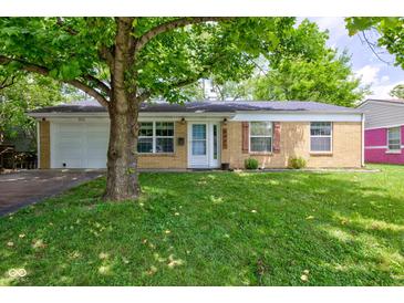 Charming brick home with a well-maintained lawn and mature tree providing shade at 8540 E 37Th Pl, Indianapolis, IN 46226
