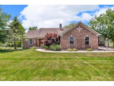 Brick ranch style home with a well-maintained lawn and a walkway leading to the front door at 10174 N County Road 471 E, Pittsboro, IN 46167