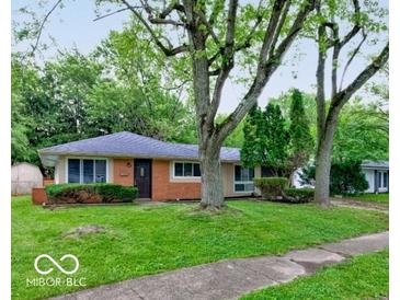 Charming single-story home with a brick facade and a well-maintained lawn, framed by mature trees at 3513 Ireland Dr, Indianapolis, IN 46235
