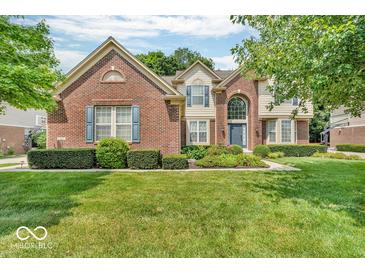 Charming two-story brick home with manicured lawn, lush shrubbery and beautiful curb appeal at 5865 Osage Dr, Carmel, IN 46033