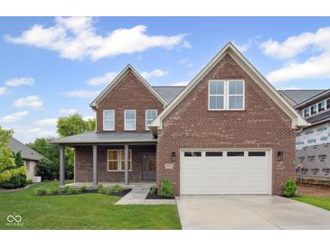 Beautiful two-story brick home with a covered front porch, an attached two-car garage, and well-manicured lawn at 6553 Stone Pointe Way, Indianapolis, IN 46237
