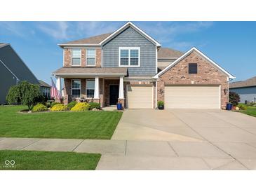 Inviting two-story home featuring brick accents, a well-manicured lawn, and a two-car garage at 6664 Kara Ln, Brownsburg, IN 46112