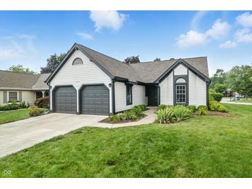 Charming home with two-car garage, manicured lawn, and inviting front entrance at 7914 Trotwood Cir, Indianapolis, IN 46256