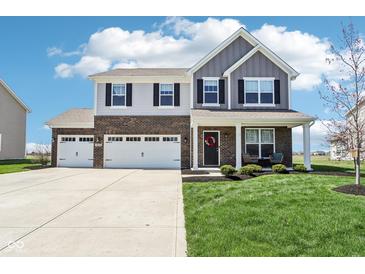 Charming two-story home with a brick and siding facade, three-car garage, and well-manicured lawn at 9916 Gallop Ln, Fishers, IN 46040