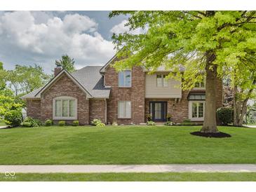 Charming brick two-story home featuring lush front lawn and mature trees in a desirable location at 1393 Stoney Creek Cir, Carmel, IN 46032