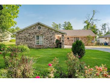 Well-maintained brick house with a green lawn, mature shrubs, and a charming garden at 450 W 250 N, Lebanon, IN 46052