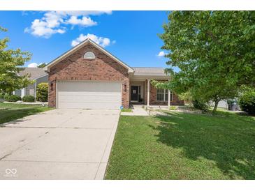 Charming brick home featuring an attached two-car garage and a well-maintained front lawn at 452 Southern Pines Dr, Whiteland, IN 46184