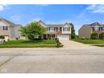 Charming two-story home with a well-manicured lawn, attached garage, and inviting front porch at 6848 Harriet Dr, Indianapolis, IN 46237