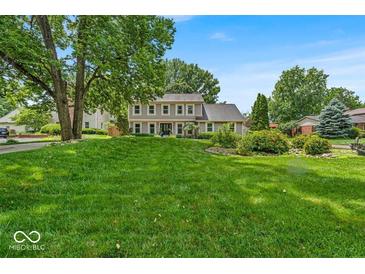 Inviting two-story home boasts lush front lawn and meticulously maintained landscaping, offering great curb appeal at 7502 Colony Cir, Indianapolis, IN 46260