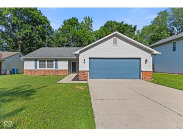 Charming single-story home featuring a blue garage door, siding, brick accents, and lush green lawn at 834 Delray Dr, Indianapolis, IN 46241