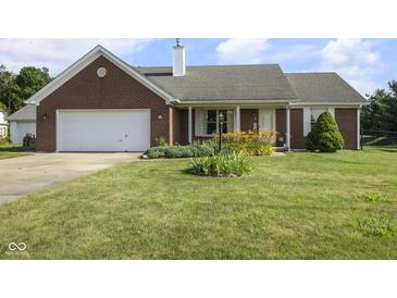 Charming red brick ranch home featuring an attached two-car garage and a well-manicured front yard at 1016 W Creek Ridge Dr, Fountaintown, IN 46130