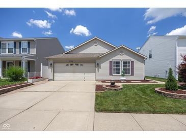 Charming single-Gathering home with a well-manicured lawn and attached two-car garage at 10758 Cyrus Dr, Indianapolis, IN 46231