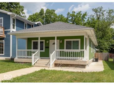 Charming bungalow with a green exterior, white trim, a front porch, and a well-manicured lawn at 1122 W 35Th St, Indianapolis, IN 46208