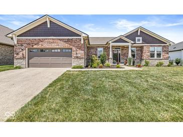 Charming brick home with well-manicured lawn and lovely front garden at 1165 Maclaren Ct, Franklin, IN 46131