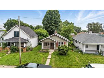 Charming single-story home with a cozy front porch and mature trees in a residential neighborhood at 1550 Hoefgen St, Indianapolis, IN 46203