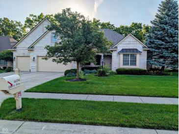 Charming brick home with a well-manicured lawn, mature trees, and a convenient two-car garage at 16254 Quartz Dr, Noblesville, IN 46060