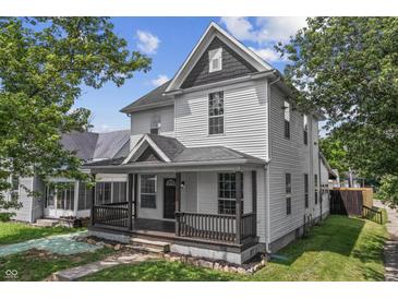 Charming two-story home featuring a covered front porch, classic white siding, and lush landscaping at 2001 S Jefferson St, Muncie, IN 47302