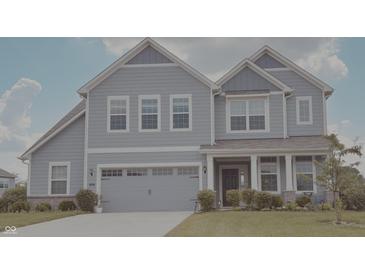 Charming two-story home showcasing light-blue siding, a two-car garage and a well manicured lawn at 5527 Mahogany Dr, Noblesville, IN 46062