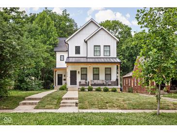 Charming two-story home with a welcoming front porch and a well-manicured lawn at 5678 N College Ave, Indianapolis, IN 46220