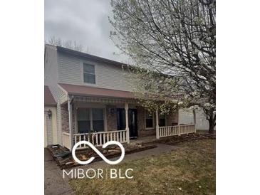 Charming two-story home with a welcoming front porch and mature flowering tree at , Indianapolis, IN 46254