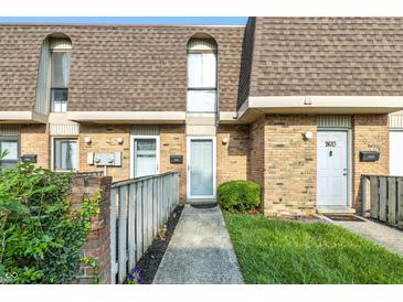 Charming brick townhome with well-manicured lawn and inviting entryway at 7468 Countrybrook Dr, Indianapolis, IN 46260