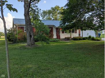 A single-story home with a well-manicured lawn and mature trees under a sunny sky at 8923 Maze Rd, Indianapolis, IN 46259