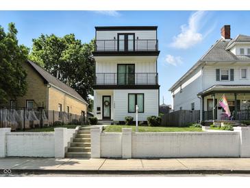 Modern three-story home with white siding, black trim, and a double-balcony facade offers stylish curb appeal at 1405 E Vermont St, Indianapolis, IN 46201