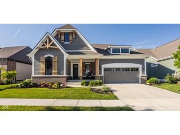 Charming two-story home featuring a gray exterior, manicured lawn, and welcoming front porch at 15600 Woodford Dr, Westfield, IN 46074