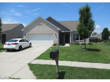 Charming one story home with white brick, manicured lawn, and an attached two car garage at 7232 Moultrie Dr, Indianapolis, IN 46217
