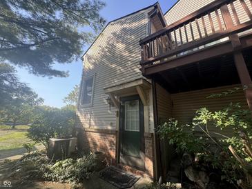 Exterior view of townhome with siding, brick facade, and second story deck at 9552 Maple Way, Indianapolis, IN 46268
