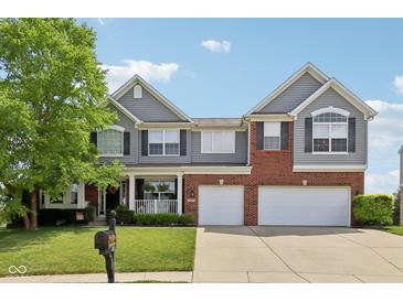 Charming two-story home with a brick and siding exterior, attached two-car garage, and well-manicured lawn at 10716 Patoka Rd, Indianapolis, IN 46239