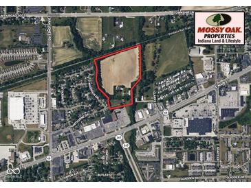 Aerial view of property outlined in red showing home and surrounding land with road and neighborhood at 2000 Hawthorne Dr, Plainfield, IN 46168