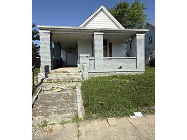 Street view of a single Gathering home, with a covered porch and weathered facade at 2215 Noble St, Anderson, IN 46016