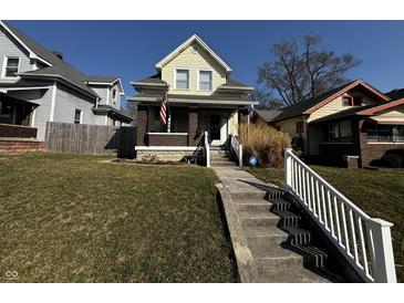 Charming two-story home with a landscaped front yard, American flag, and inviting porch at 429 Wallace Ave, Indianapolis, IN 46201
