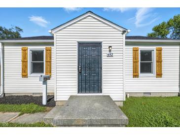 Charming home featuring a decorative security door, white siding, and wood shutters at 452 N Fenton Ave, Indianapolis, IN 46219
