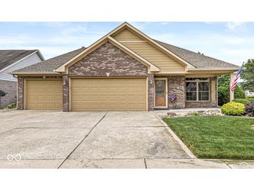 Charming brick home featuring a two-car garage, manicured lawn, and inviting curb appeal at 5659 Augusta Woods Dr, Plainfield, IN 46168