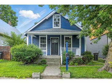Charming blue home with white trim, front porch, and well-maintained landscaping at 1151 S Randolph St, Indianapolis, IN 46203