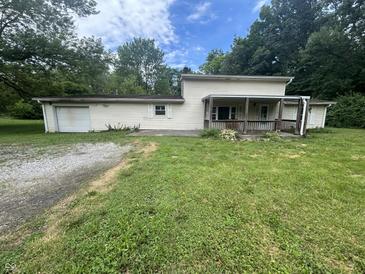 Charming two-story home with a covered porch, attached garage, and a spacious front yard at 1330 Schleicher Ave, Indianapolis, IN 46229