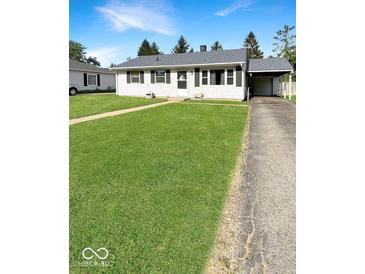 Charming single-story home with a well-maintained lawn, attached carport, and classic black shutters at 205 Eikenberry St, Greenfield, IN 46140
